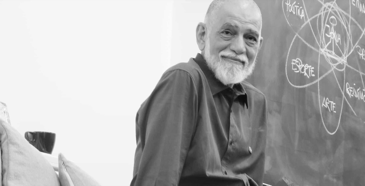 Professor DeRose ao lado de um quadro negro com desenhos de giz